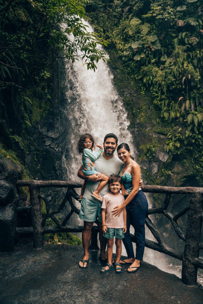 Family standing in front of La Pax Waterfall Gardens Waterfall