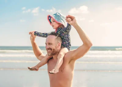 Father carrying daughter on shoulders at the beach in Costa Rica