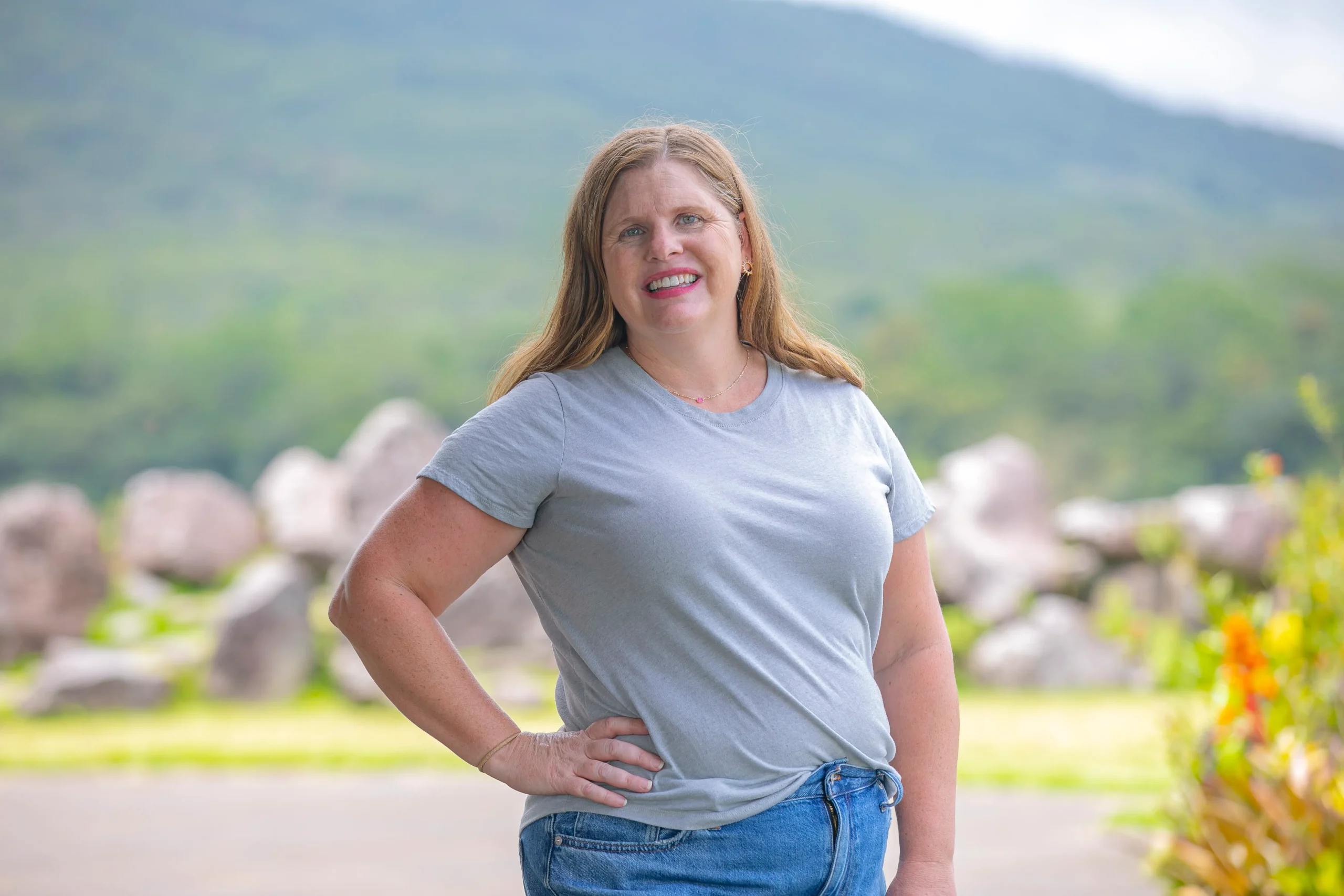 Christa from Pura Vida Moms smiling outdoors in Costa Rica with a mountain background.