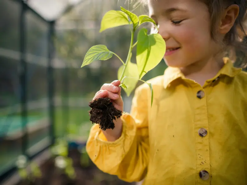 Smiling girl holding a plant during nature exploration in Costa Rica
