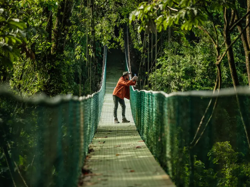 Family adventure crossing a hanging bridge in the rainforest of Costa Rica