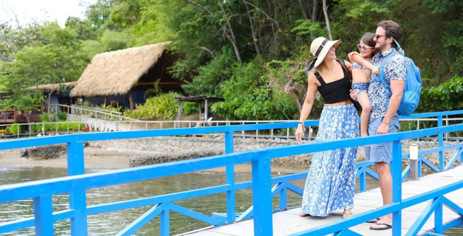 Family walking on a blue bridge at a kid-friendly eco-lodge in Costa Rica