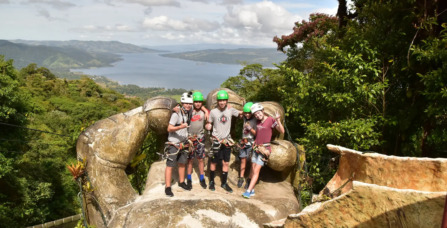 Group of teens and parents on a Costa Rica canopy platform overlooking jungle and lake