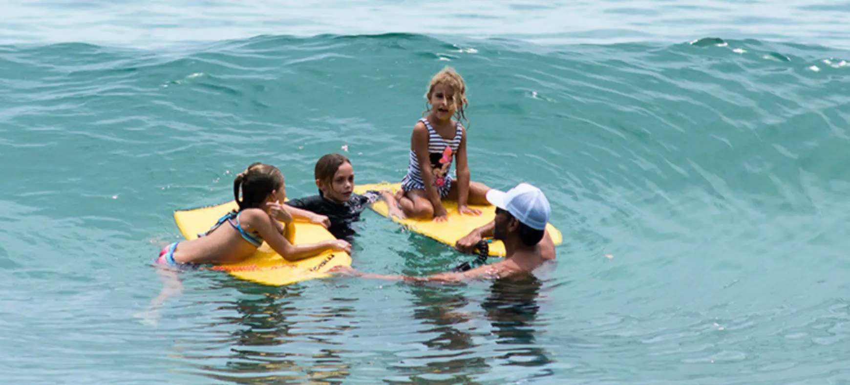 Kids swimming in the ocean during a family beach day in Costa Rica
