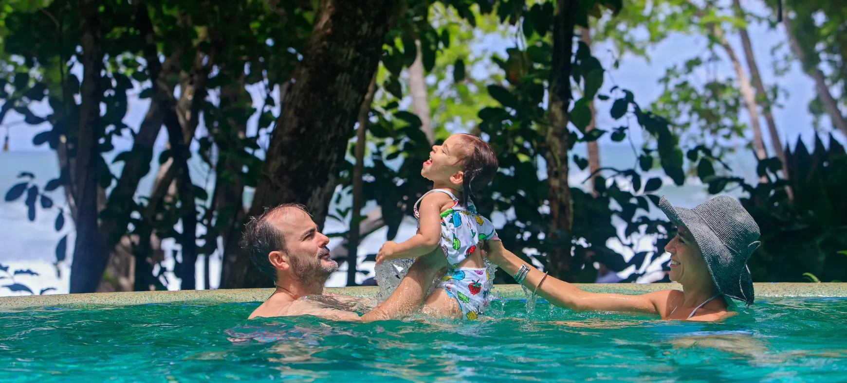 Father playing with baby in a pool during a Costa Rica family vacation